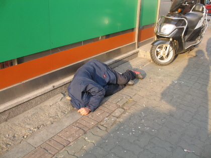 거리에서 불편한 잠을 청하고 있는 노숙인 